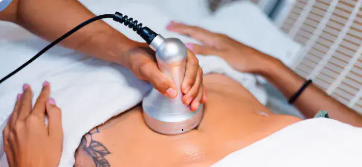 Non-surgical cellulite treatment on the abdomen with a handheld clinical applicator in a spa setting - Dr. Elham Keikha Dubai