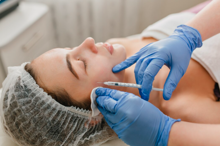 Cheek filler injection along the mid-face by a gloved specialist in a Dubai aesthetic clinic
