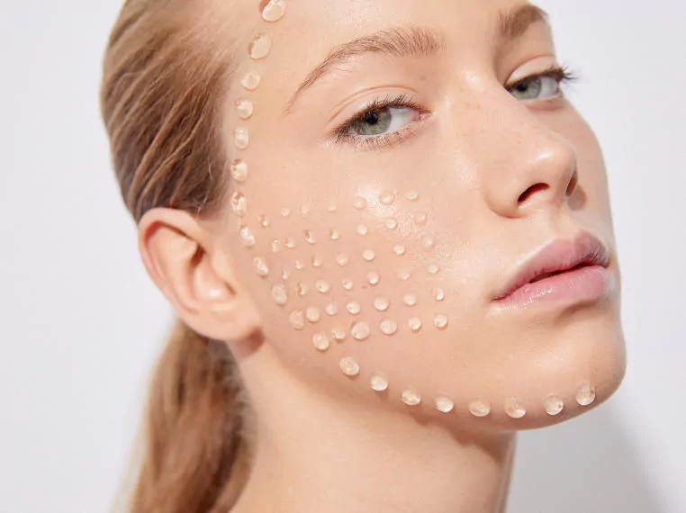 Close-up of a medical professional using a precision measuring tool on a patient's face to assess the treatment area before a skin booster procedure in Dubai