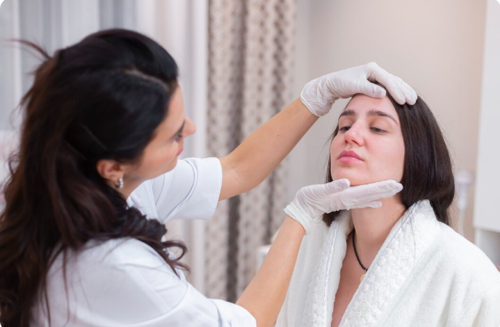 Practitioner performing a professional facial skin examination during a medical-grade skincare consultation at Dr. Elham's clinic