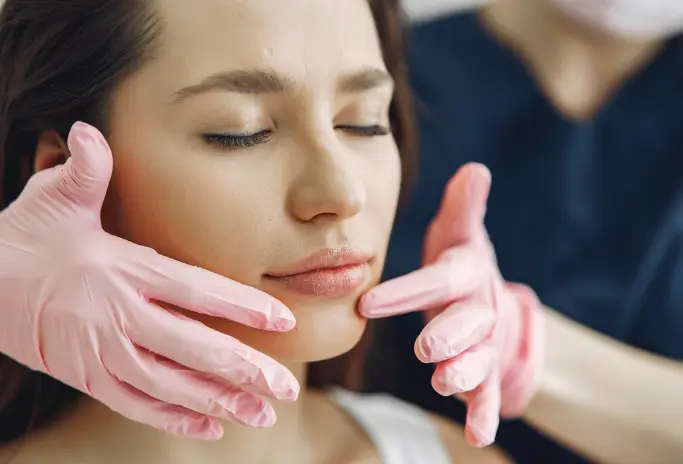 أخصائية تقيّم بلطف شفاه المريضة ومعالم وجهها لنتائج تجميل شفاه طبيعية في دبي
