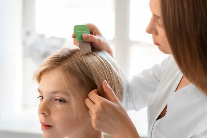Specialist examining the scalp with a fine-toothed comb during polynucleotide therapy assessment in Dubai