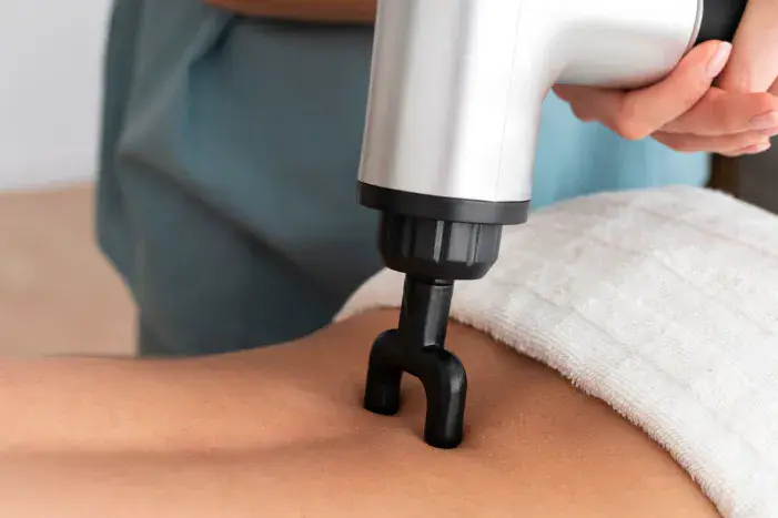 Body RF Microneedling treatment on a patient's back with a specialized handheld device in a clinical setting in Dubai