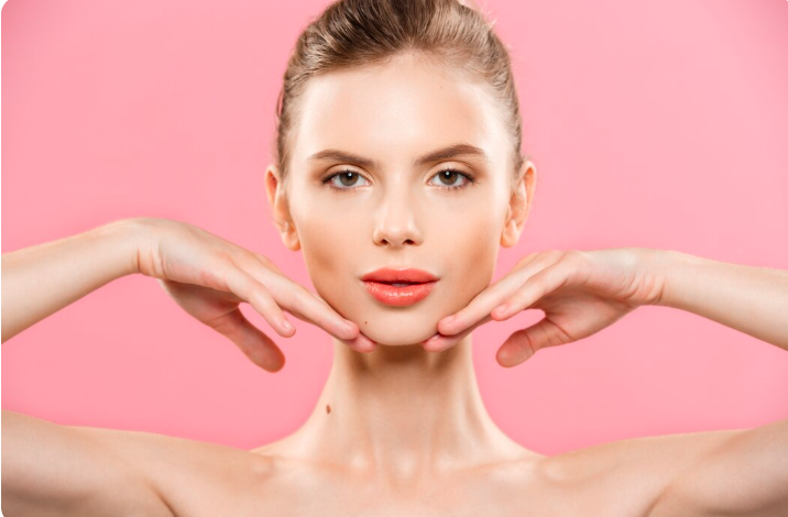 Close-up portrait of a woman with smooth radiant skin framing her jawline with her hands to demonstrate skin firmness and elasticity for skin tightening treatment