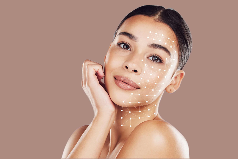 Young woman with radiant skin and a digital geometric mesh overlay on her face, symbolizing skin analysis and candidacy for skin booster treatments in Dubai