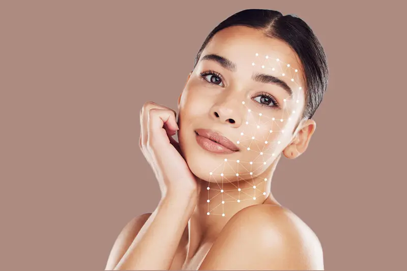 امرأة شابة ببشرة مشرقة مع شبكة هندسية رقمية على وجهها، ترمز إلى تحليل البشرة والترشيح لعلاجات معززات البشرة في دبي