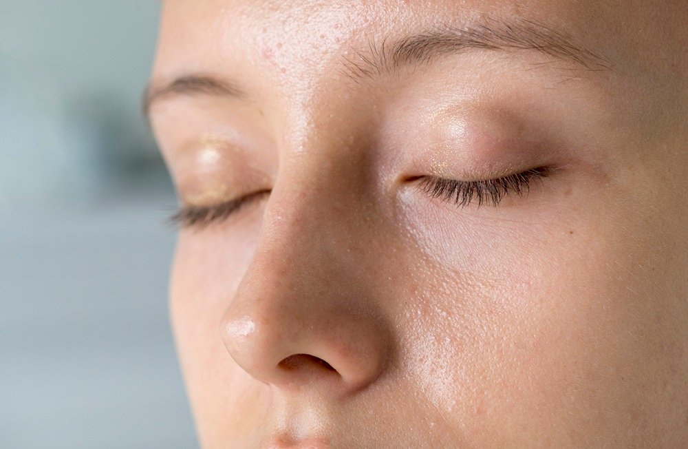 Oily skin tends to produce more sebum and may appear shiny,