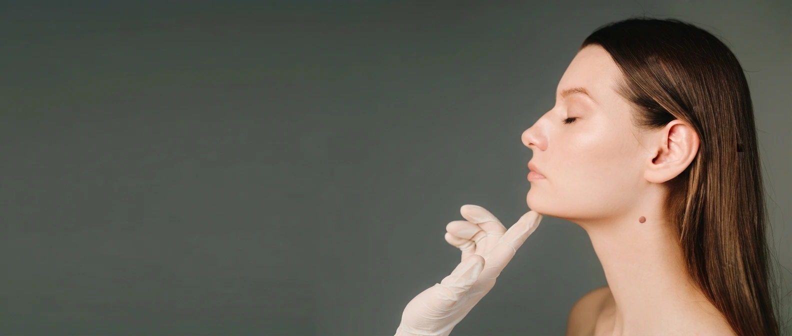Clinical consultation focusing on the chin and jawline of a woman with eyes closed, representing non-surgical double chin reduction treatment in Dubai - Dr. Elham Keikha